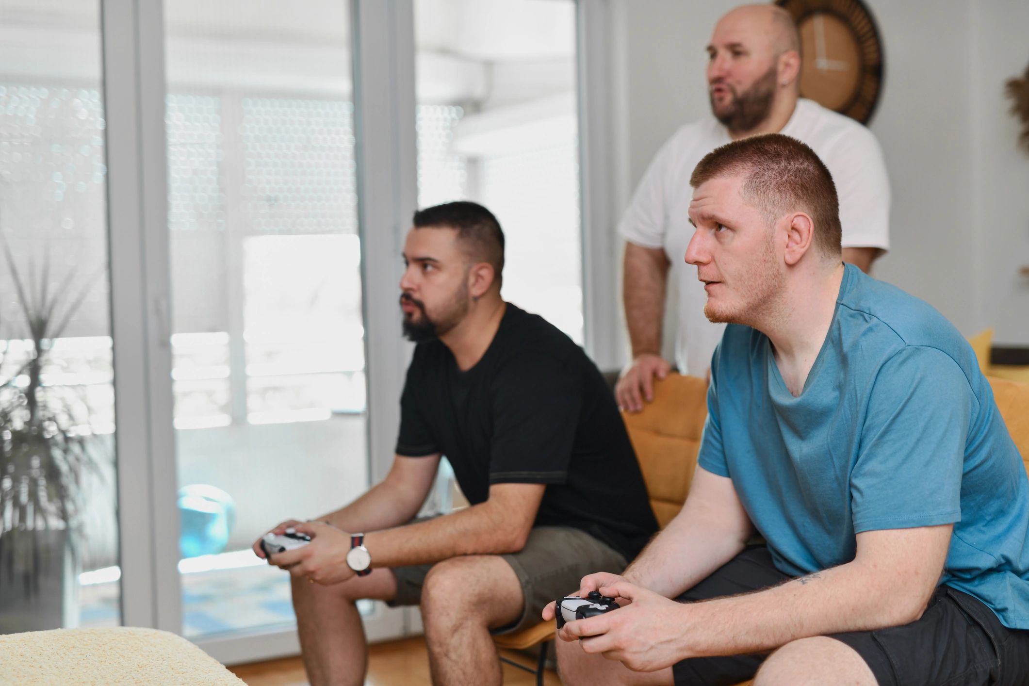 Friends competing in a video game while others cheer