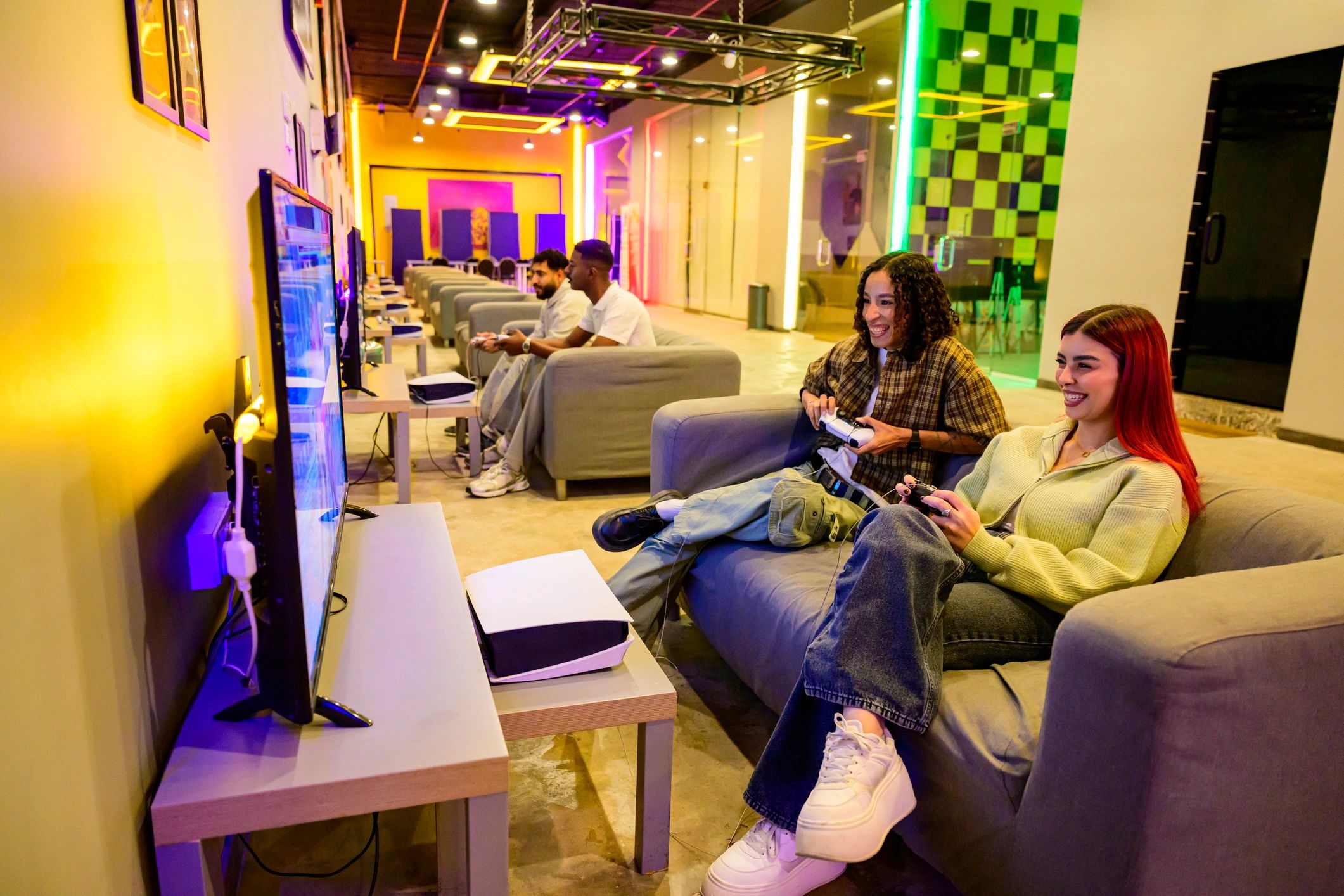 Young adults playing video games together in a gaming lounge
